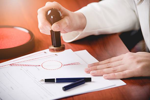 Woman Notary Public stamping the contract. Law office.